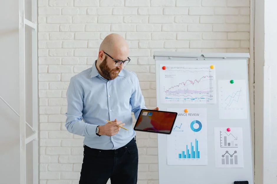 Un homme analyse des stratégies de contenu marketing à l’aide de notes autocollantes sur un tableau blanc.